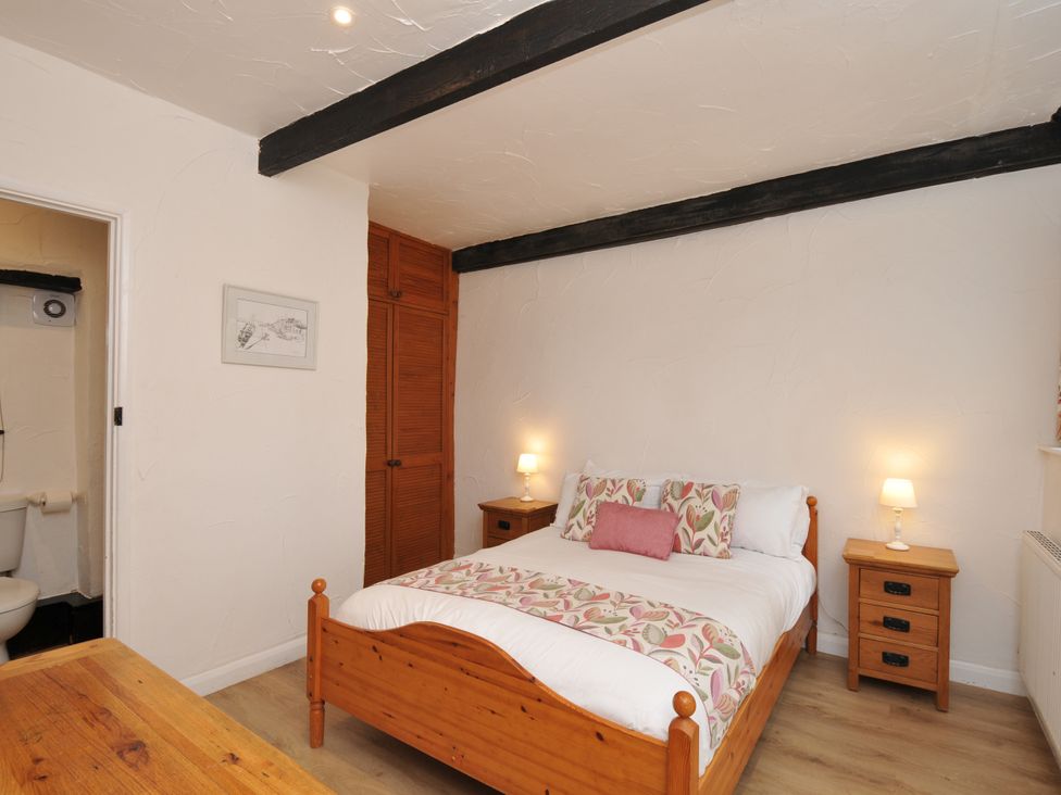 A bedroom with a bed and nightstands at Barley Cottage in Hartland