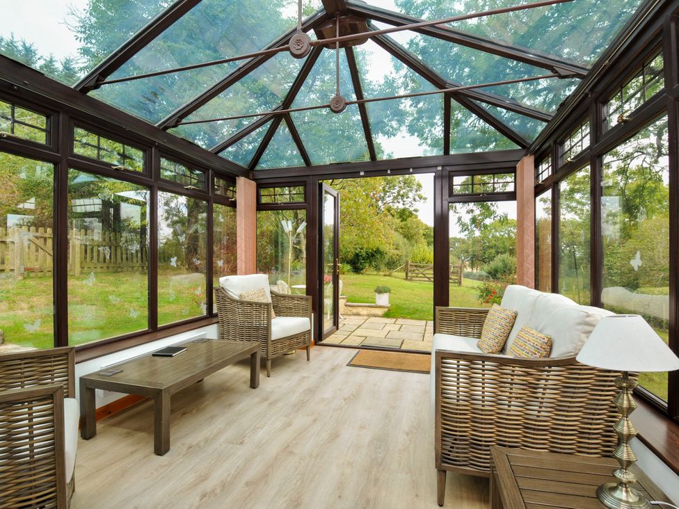 A conservatory with seating area at Barley Cottage in Hartland