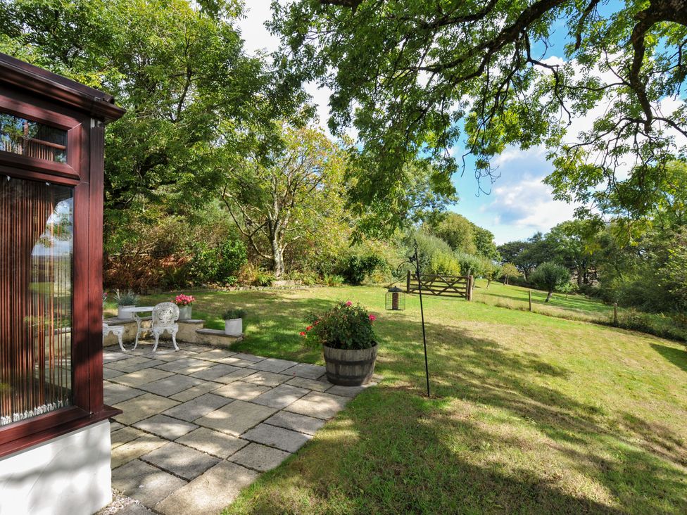 A garden with a patio and seating area at Barley Cottage in Hartland