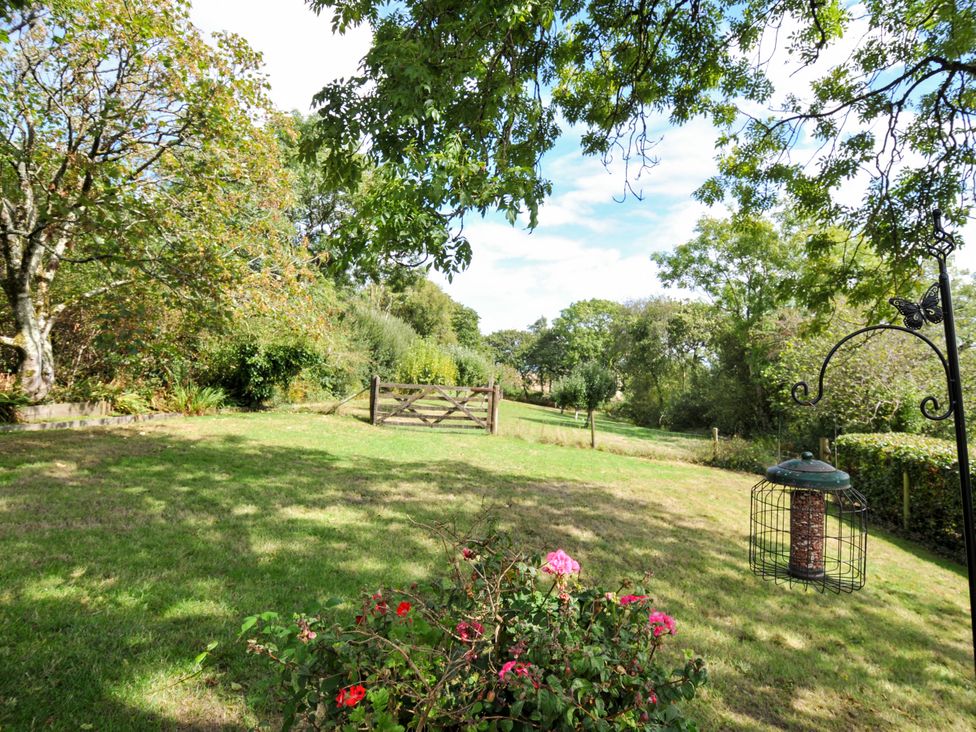 A garden with a gate and trees at Barley Cottage in Hartland