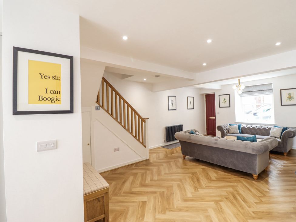 A living room with a staircase and a sofa at Neptune Cottage in Conwy