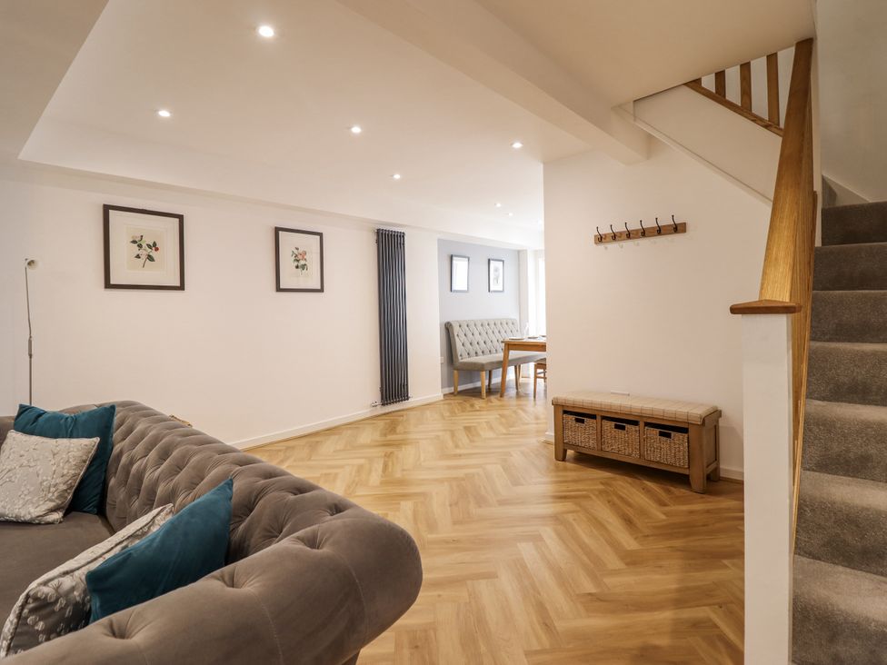 A living room with a sofa and a dining table at Neptune Cottage in Conwy