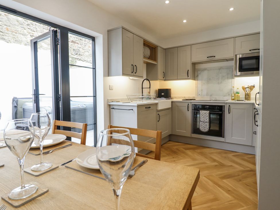 A kitchen with cabinets and appliances at Neptune Cottage in Conwy