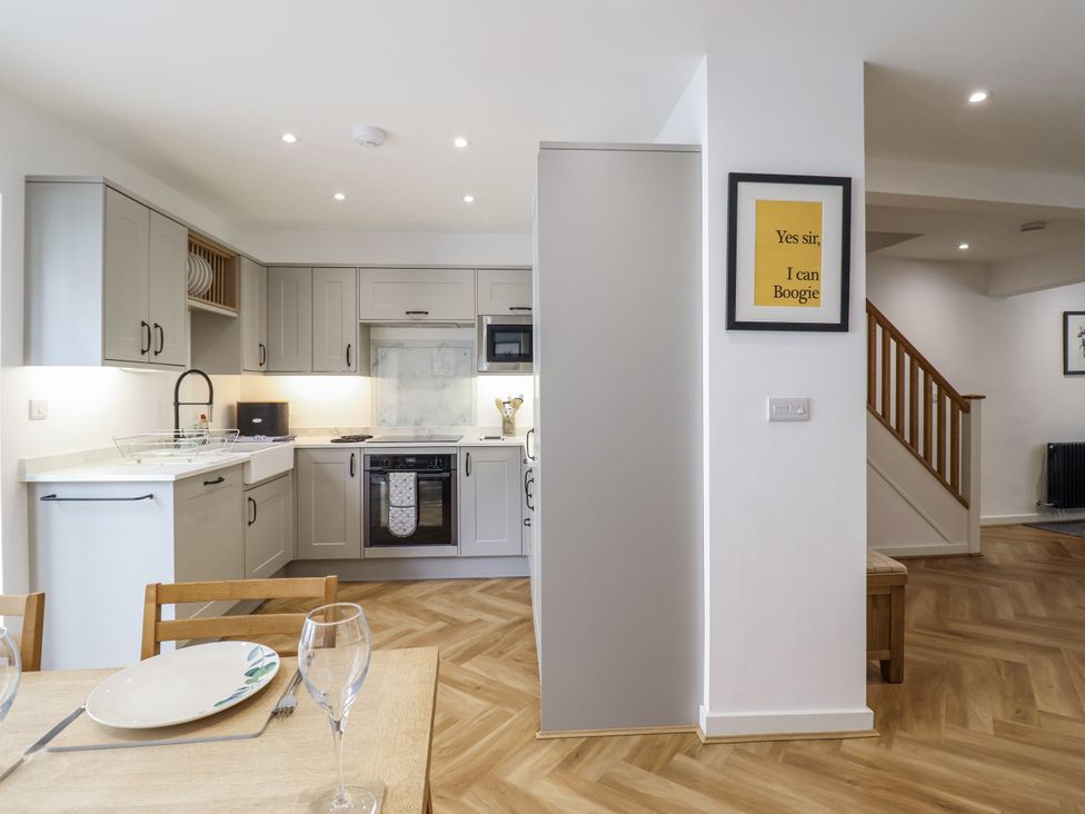 A kitchen with appliances and dining table at Neptune Cottage in Conwy