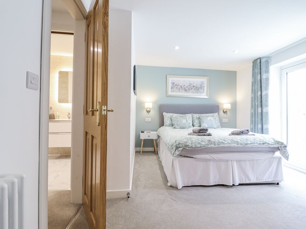 A bedroom with a bed and nightstand at Neptune Cottage in Conwy