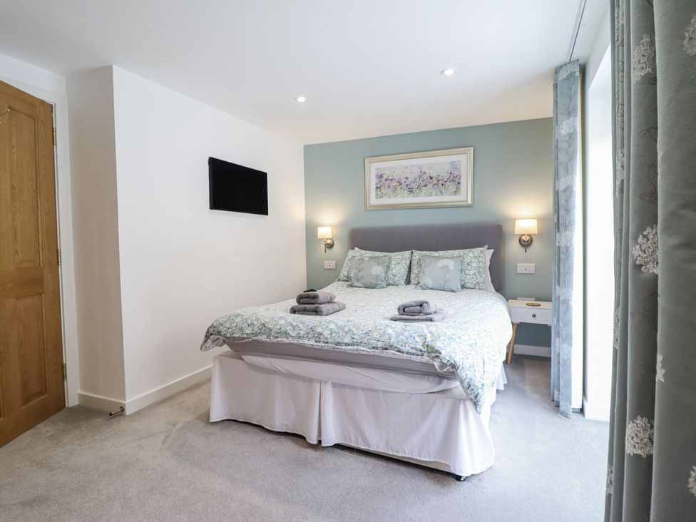 A bedroom with a bed and bedside table at Neptune Cottage in Conwy