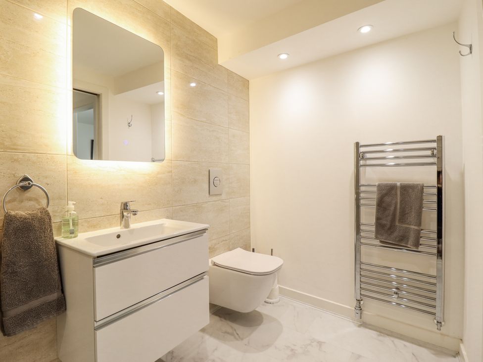 A bathroom with a sink and towel rack at Neptune Cottage in Conwy