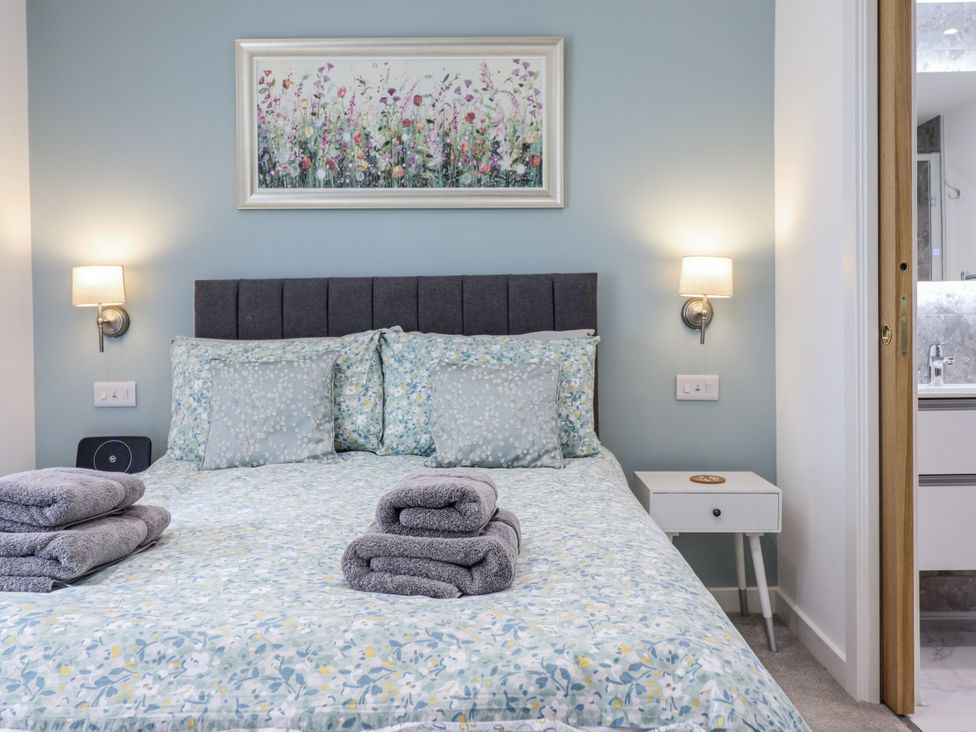 A bedroom with a bed and bedside table at Neptune Cottage in Conwy