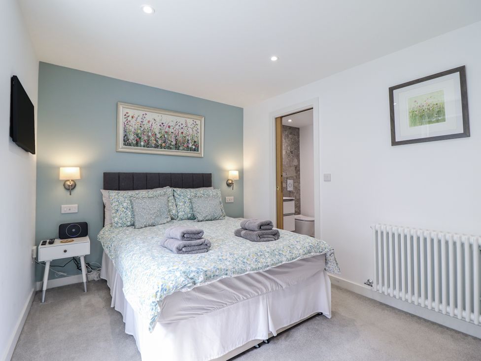 A bedroom with a bed and a bedside table at Neptune Cottage in Conwy