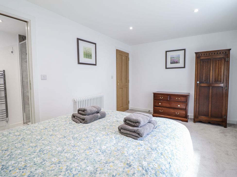 A bedroom with towels on the bed at Neptune Cottage in Conwy
