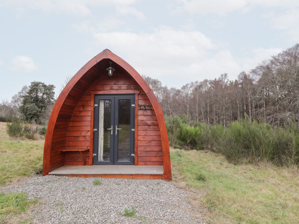 A wooden pod with a door and steps at Pod 2 in Beauly