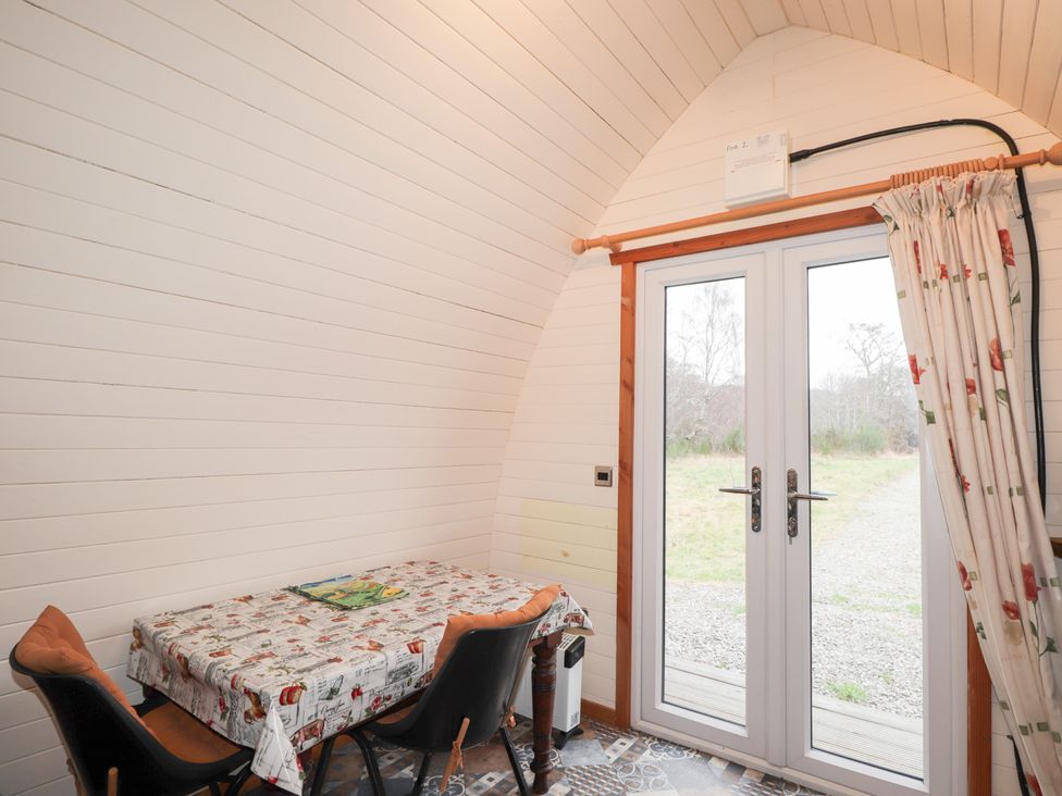 A dining area with a table and chairs at Pod 2 Beauly