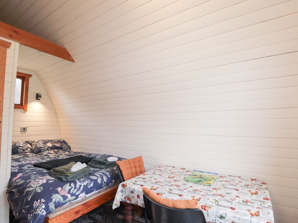 A bedroom with a bed and a table in Pod 2 Beauly