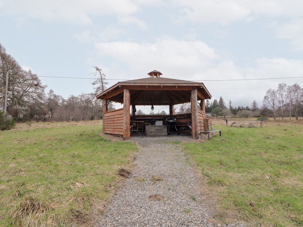 An outdoor pavilion with a table and grill at Pod 2 in Beauly