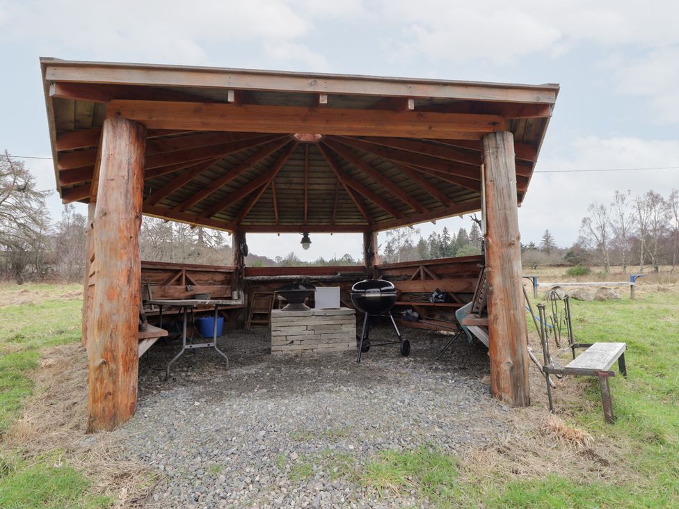 An outdoor gazebo with seating and a grill at Pod 2 in Beauly