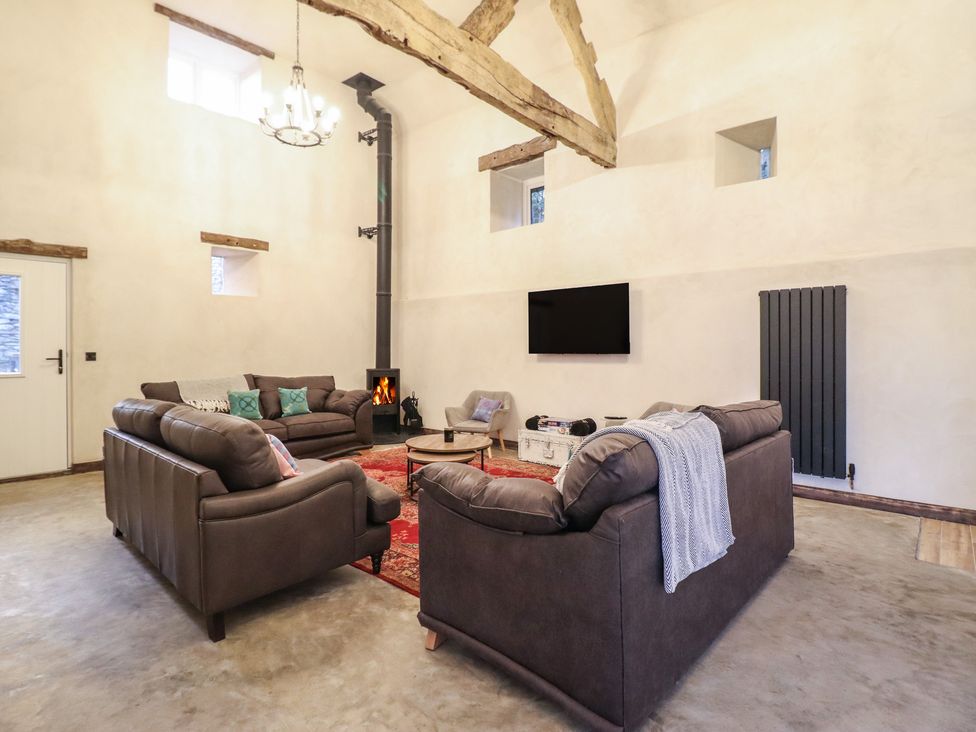 A living room with sofas and a fireplace at Godre'r Gyrn, Plas Moelfre Hall Barns in Oswestry