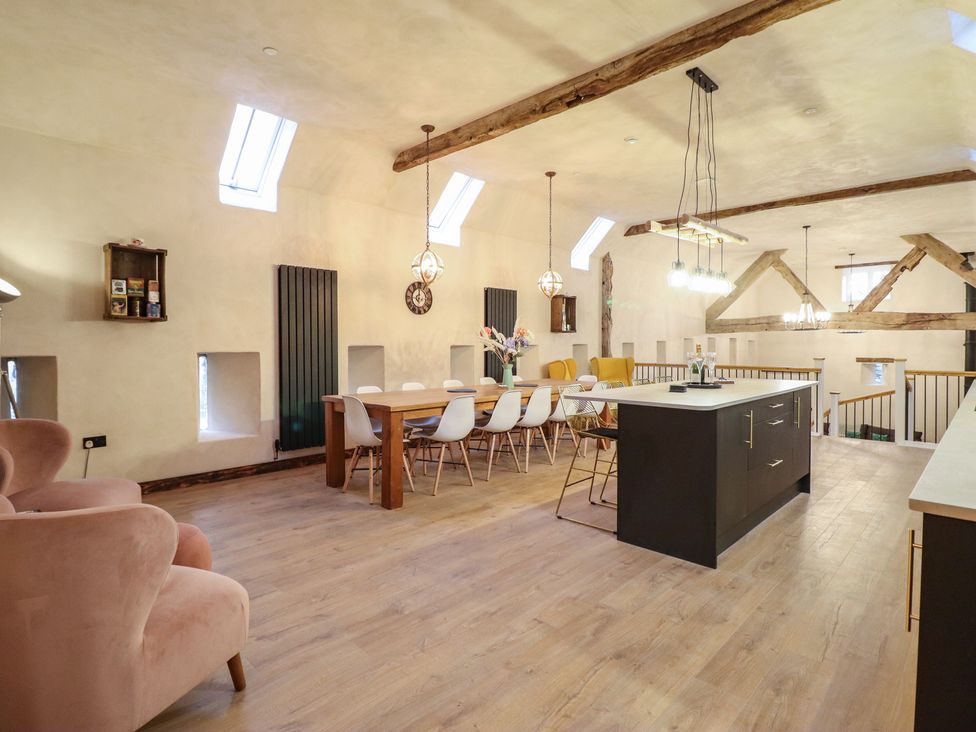 An open plan kitchen and dining area with a table and chairs at Godre'r Gyrn, Plas Moelfre Hall Barns, Oswestry