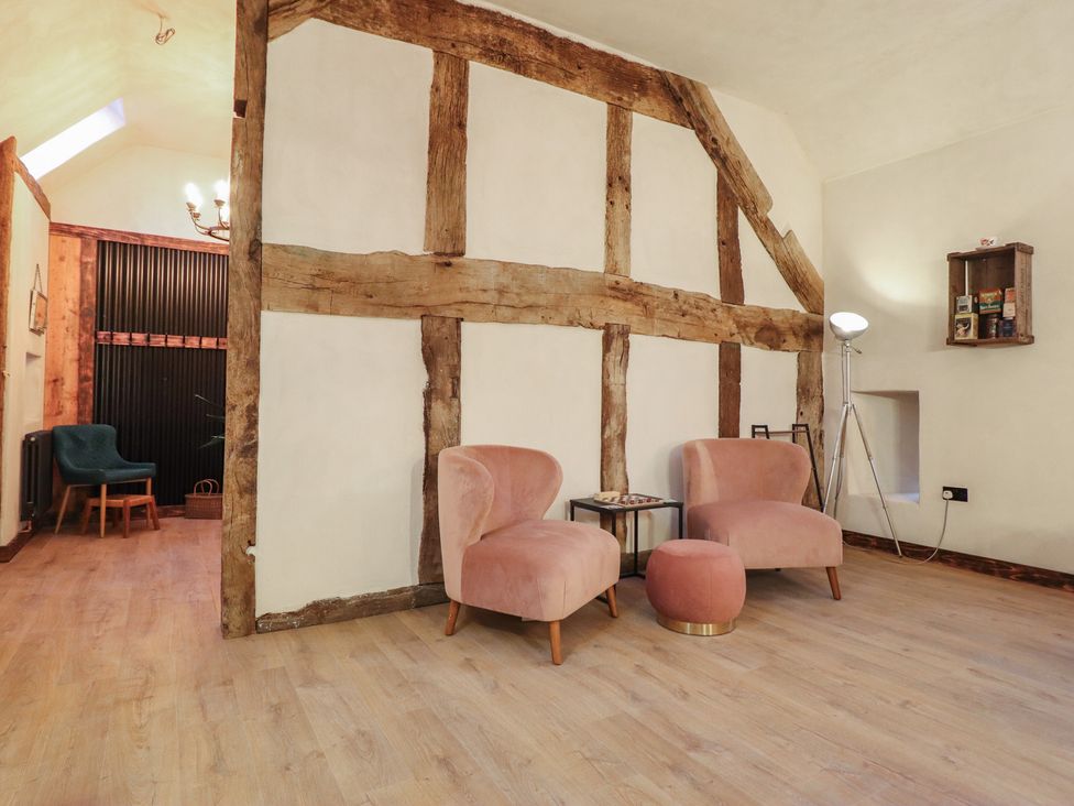 A living room with two chairs and a small table at Godre'r Gyrn, Plas Moelfre Hall Barns in Oswestry
