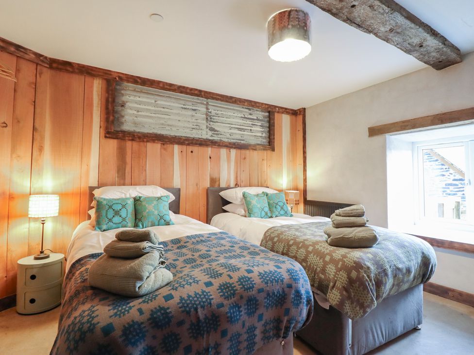 A bedroom with two beds and a window at Godre'r Gyrn, Plas Moelfre Hall Barns, Oswestry