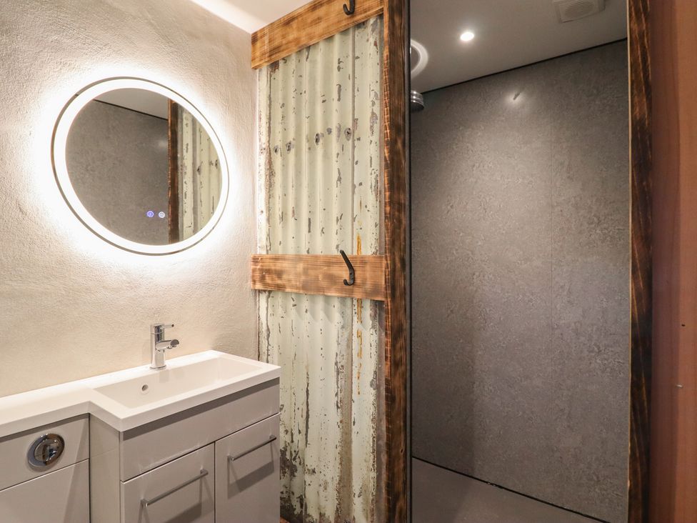 A bathroom with a sink and mirror at Godre'r Gyrn, Plas Moelfre Hall Barns in Oswestry