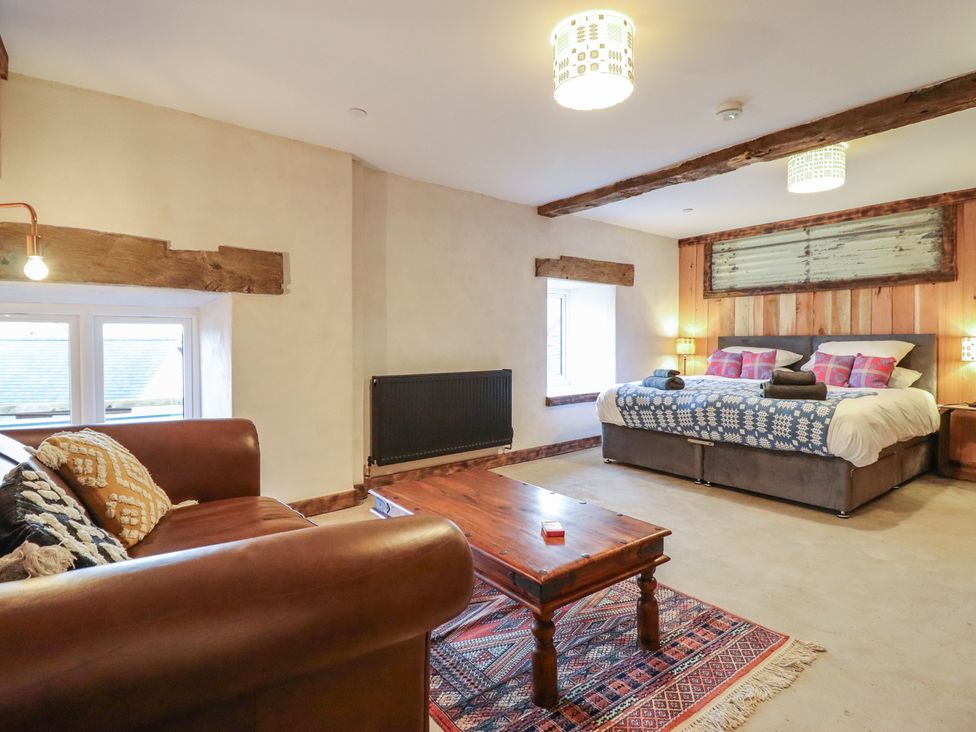 A bedroom with a double bed and sofa at Godre'r Gyrn, Plas Moelfre Hall Barns Oswestry