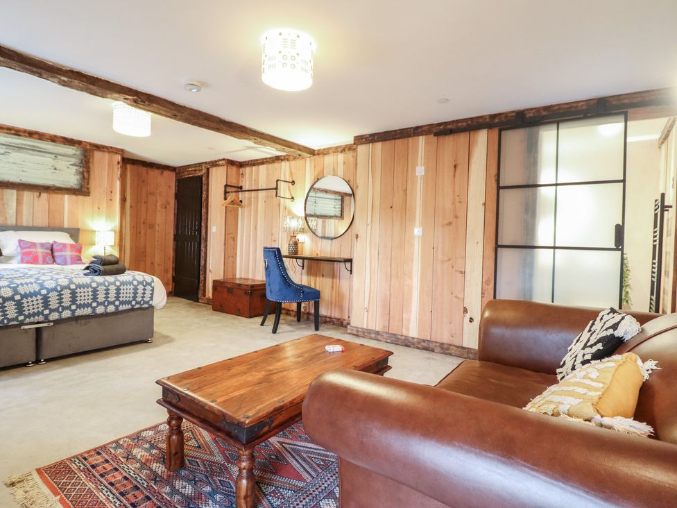 A living room with a sofa table and bed at Godre'r Gyrn, Plas Moelfre Hall Barns Oswestry