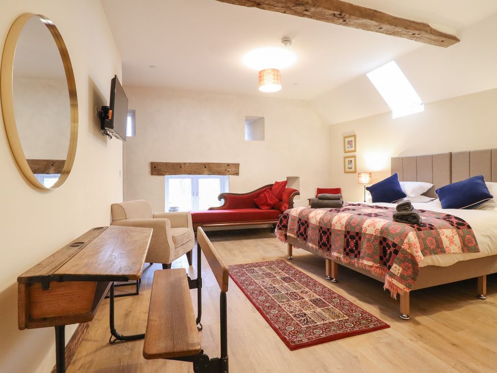 A bedroom with a bed, sofa, and table at Godre'r Gyrn, Plas Moelfre Hall Barns Oswestry