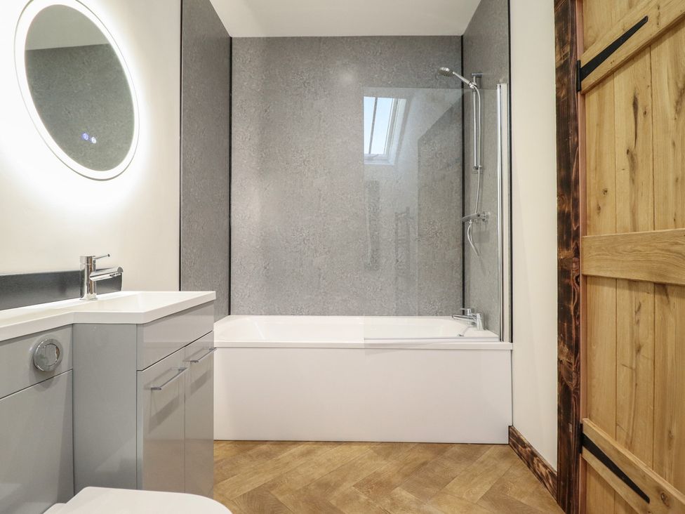 A bathroom with a bathtub and sink at Godre'r Gyrn, Plas Moelfre Hall Barns, Oswestry