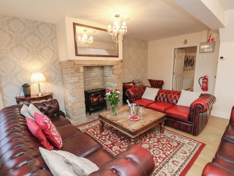 A living room with a coffee table and a fireplace at Honeysuckle in Filey