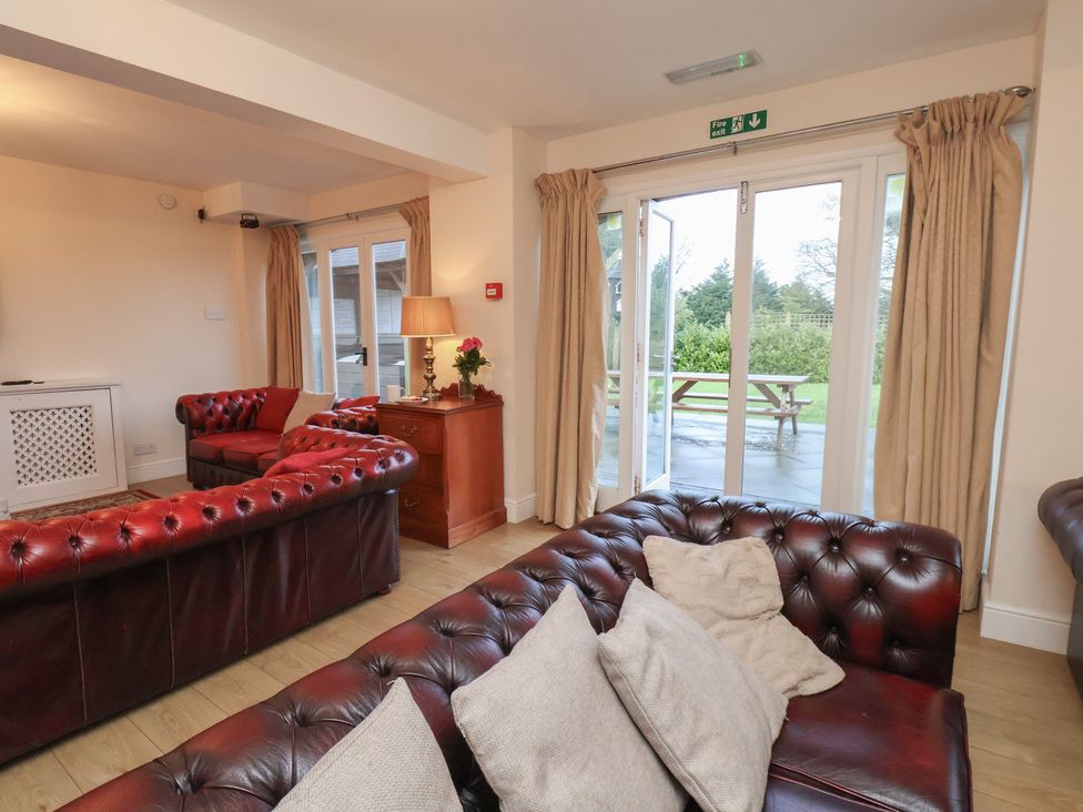 A living room with sofas and a garden view at Honeysuckle in Filey