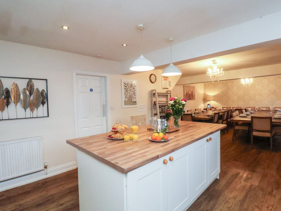 A kitchen with a central island and dining area at Honeysuckle in Filey