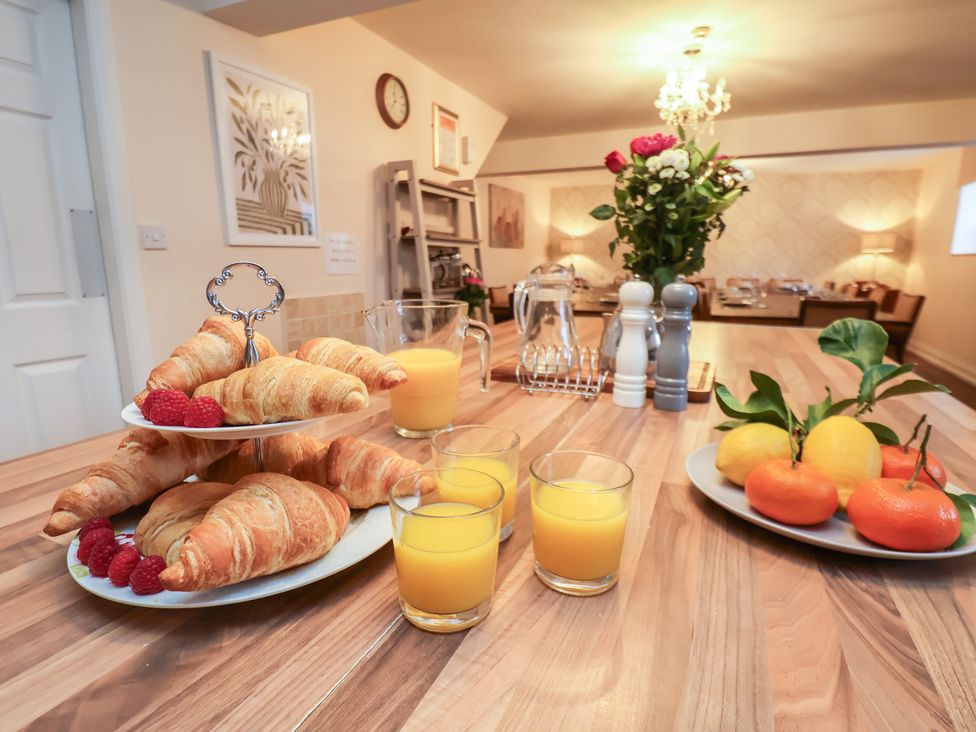 A kitchen with croissants and orange juice at Honeysuckle in Filey