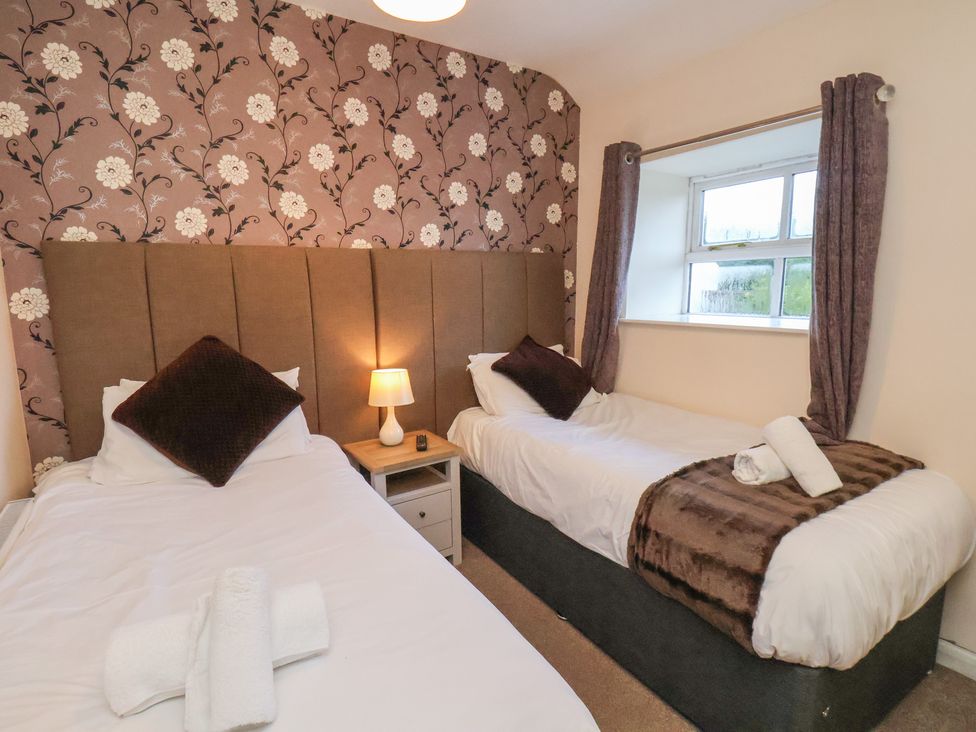 A bedroom with two beds and a window at Honeysuckle in Filey