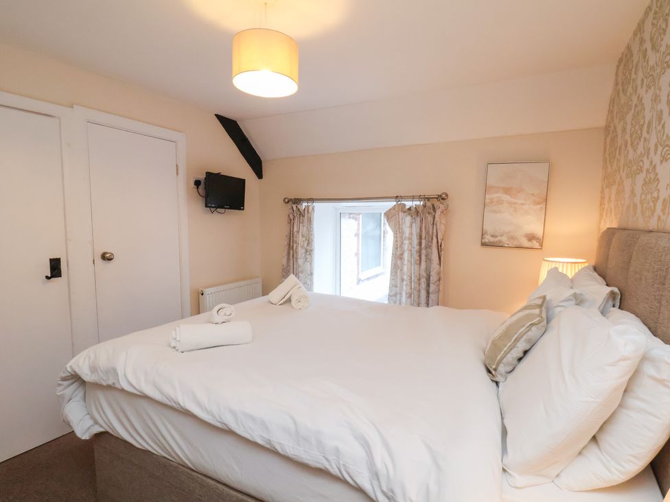 A bedroom with a bed and a TV at Honeysuckle in Filey