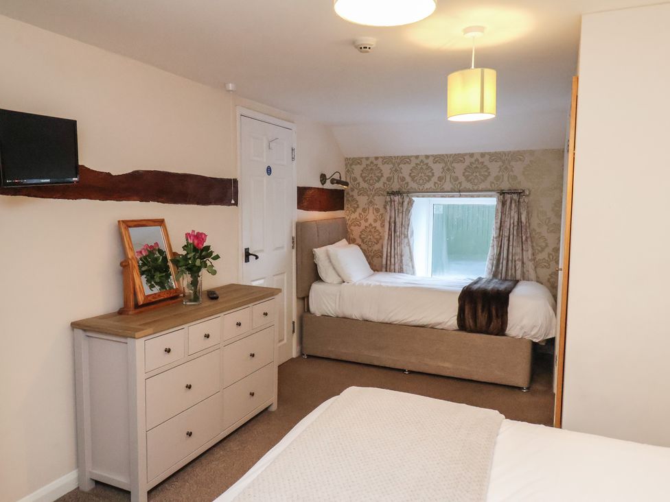 A bedroom with two beds and a dresser at Honeysuckle in Filey