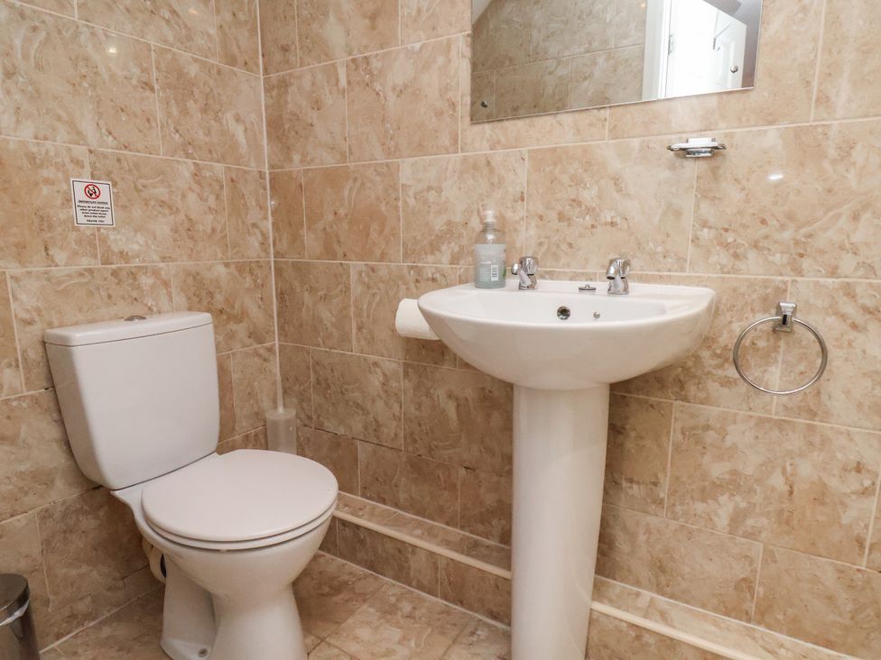 A bathroom with toilet and sink at Honeysuckle in Filey
