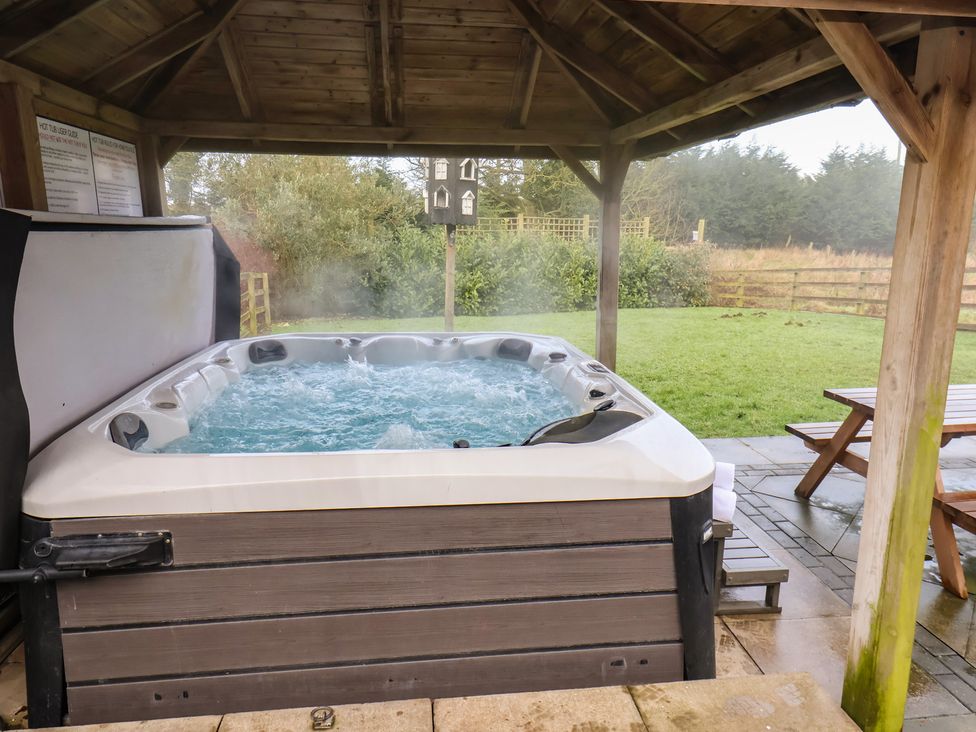 A hot tub with steaming water in an outdoor area at Honeysuckle in Filey