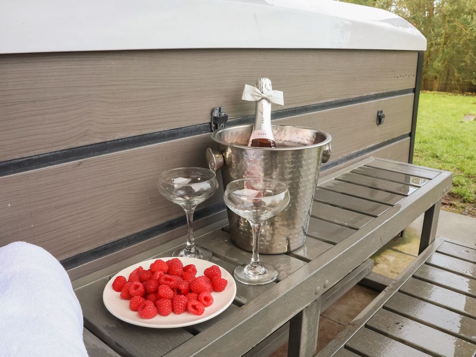 A towel and drinks on a table near a hot tub at Honeysuckle in Filey