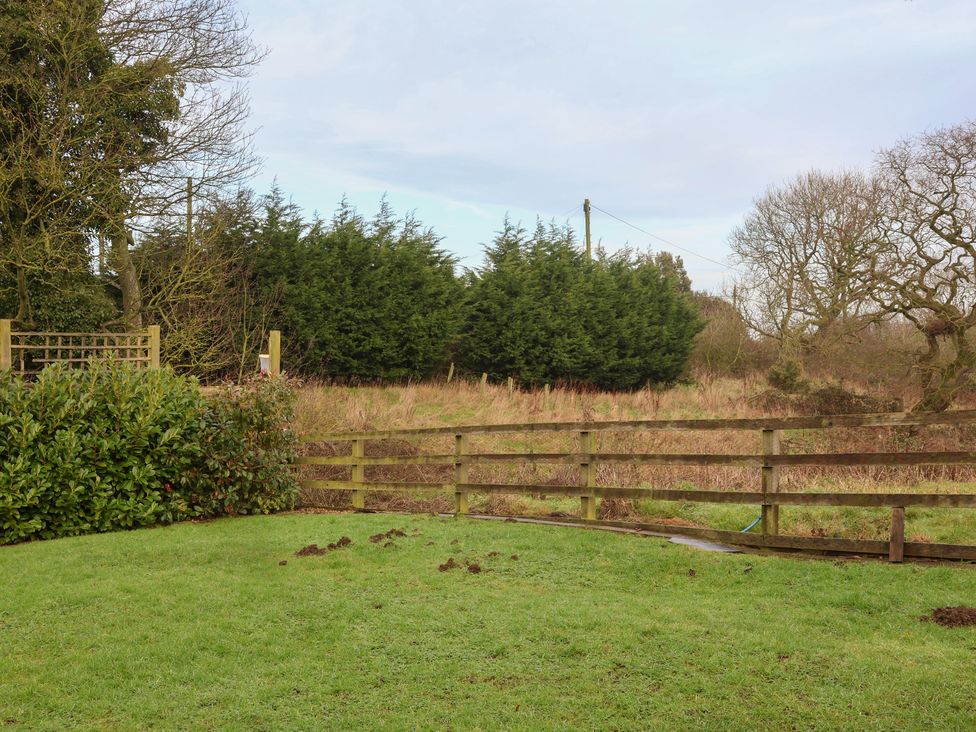 A garden featuring a fence and bushes at Honeysuckle in Filey