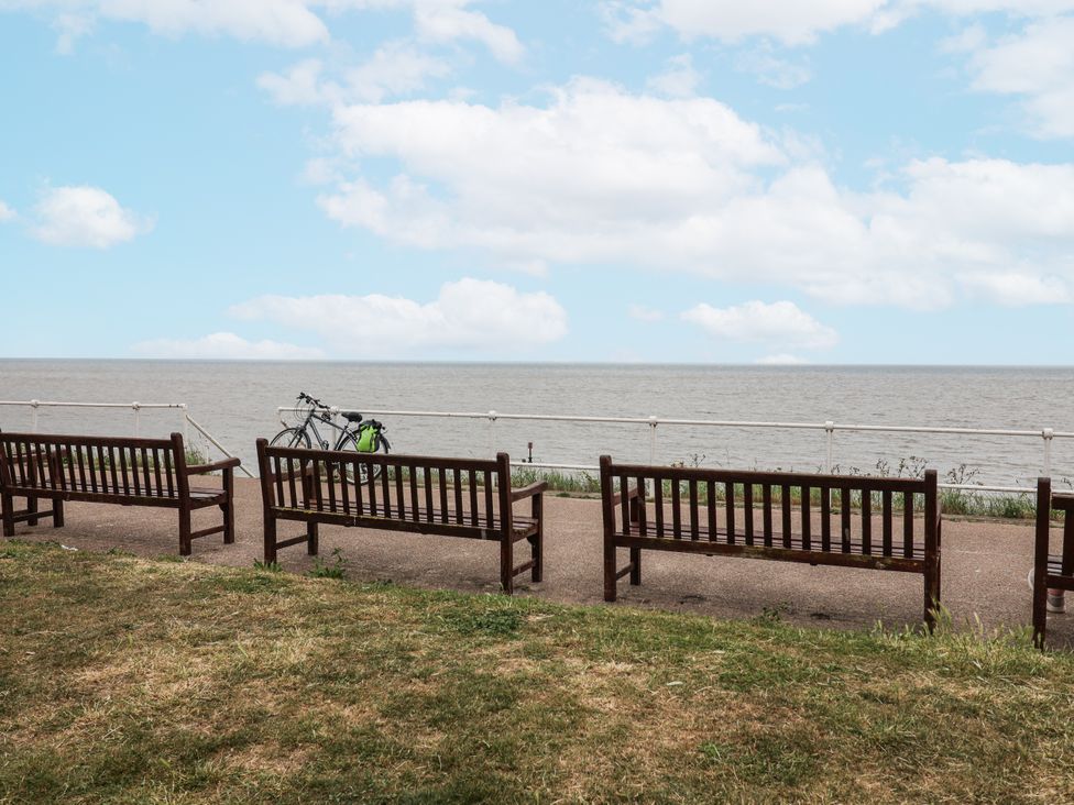 A view of benches near the sea with a bike at Astondene, East Cliff in Southwold