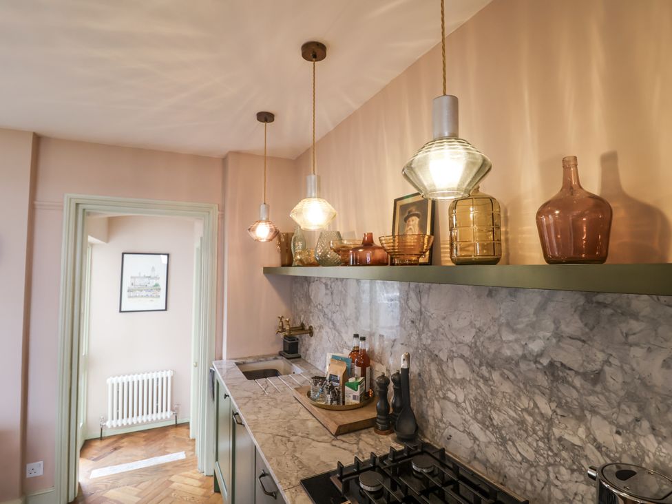 A kitchen with a sink and light fixtures at Astondene, East Cliff Southwold