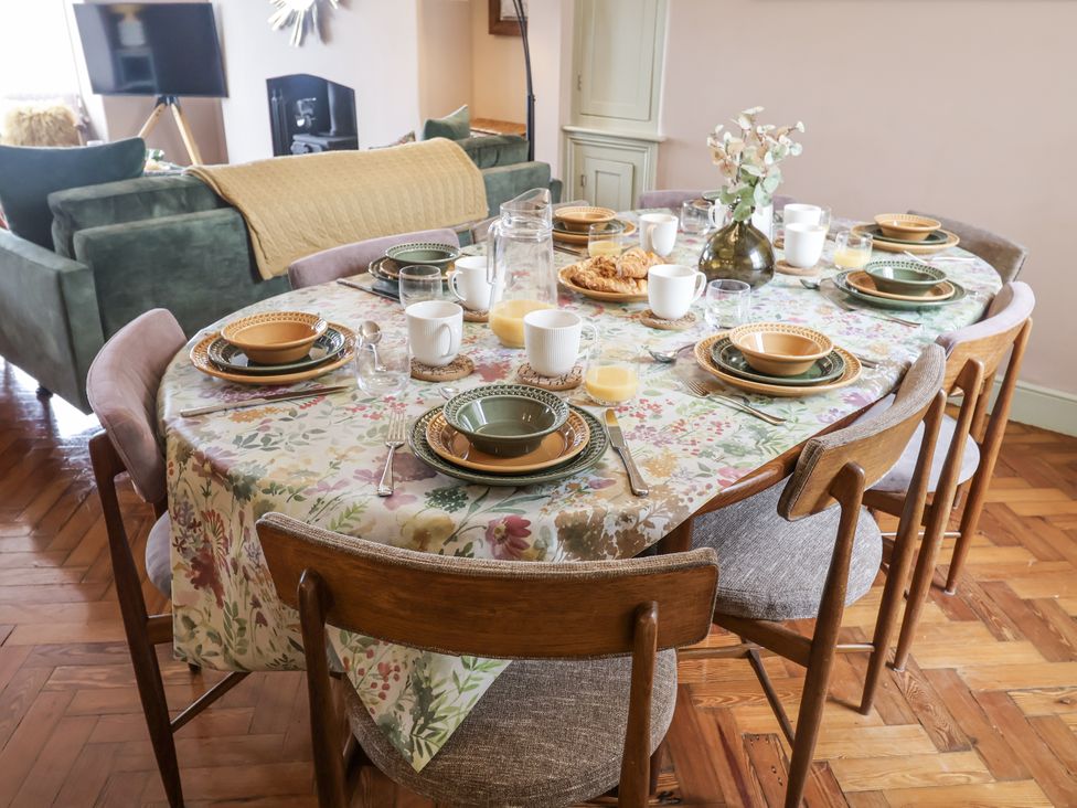 A dining room with a table set for a meal at Astondene, East Cliff, Southwold