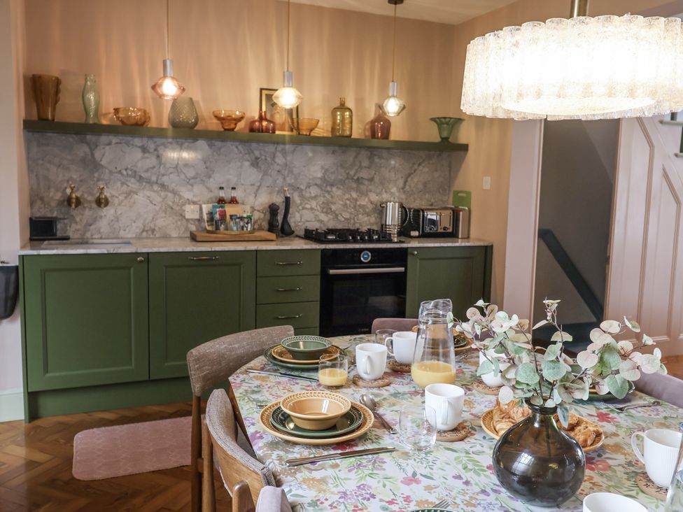 A kitchen with marble countertop and dining table at Astondene, East Cliff in Southwold