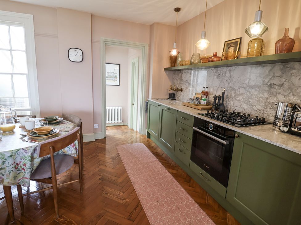 A kitchen with a dining table and chairs at Astondene, East Cliff, Southwold