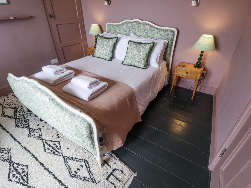 A bedroom with a bed and nightstand at Astondene, East Cliff Southwold