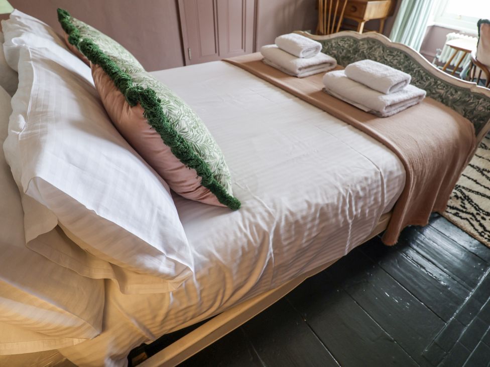 A bedroom with a bed and towels at Astondene, East Cliff, Southwold
