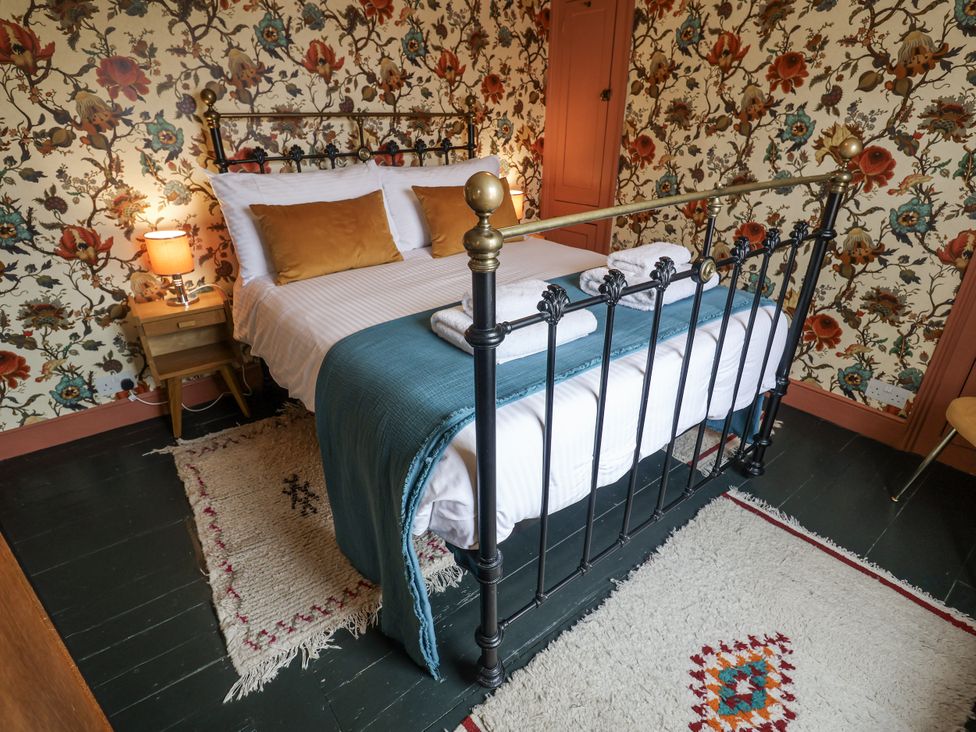 A bedroom with a bed and bedside table at Astondene, East Cliff, Southwold