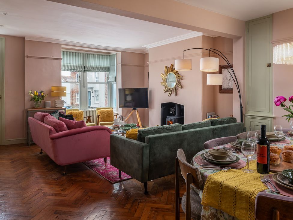 A living room with a sofa and dining area at Astondene, East Cliff Southwold