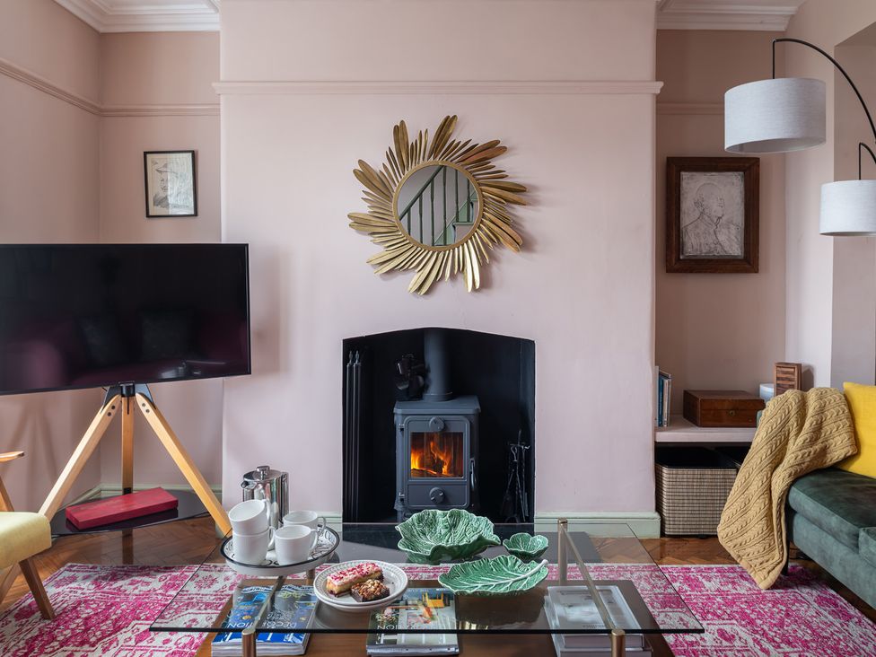 A living room with a fireplace and television at Astondene, East Cliff, Southwold