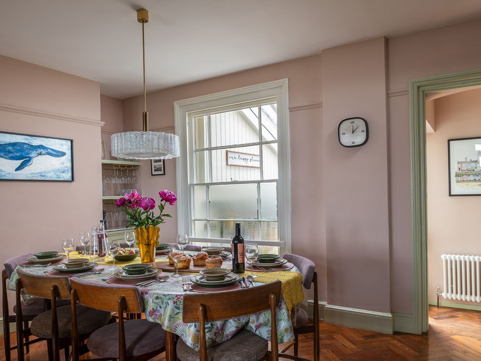A dining room with a table set for a meal at Astondene, East Cliff, Southwold